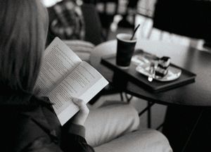 A woman sitting in a chair reading a book