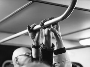 Grayscale shot of people's hands on steel bar photo