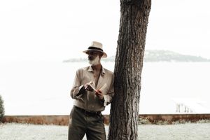 Stylish mature man reading book on waterfront